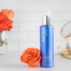 Anora Purifying Gel Cleanser bottle beside an orange rose on a counter