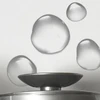 Clear toner droplets falling into a dish