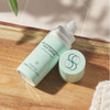 Age Intervention Face Cream bottle and cap lying on a wooden tray
