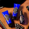 Jack Black Beard Wash, Beard Lube and Beard Oil with dominoes on a wooden table