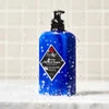 Jack Black Pure Clean Daily Facial Cleanser pump bottle splashed with water