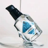 Jack Black Epic Moisture oil bottle tilted in a pool of clear oil