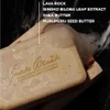 Soap bar on a dark background with lava rock and shea butter ingredient list