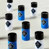 Several Jack Black Pit Boss deodorant sticks standing on a light stone surface