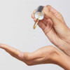 Dropper releasing oil into an open palm