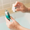 Hands filling the dropper from the Retinol Clearing Oil bottle