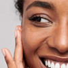 Smiling woman pressing fingertips to her cheek