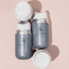Open and closed Harmonize jars on a pink background