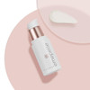 Emepelle Eye Cream bottle lying on a pink dish with a cream swatch