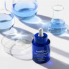 Triple Acid Peptide Peel bottle among glass beakers