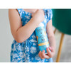 Toddler holding a Babo Botanicals SPF 30 spray bottle