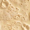 Close-up of bubbly beige exfoliant paste
