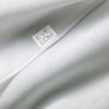 Close-up of a white Eve Lom muslin cloth with logo tag