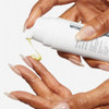 Hand pumping pale yellow Dynamic Skin Retinol Serum onto fingertips