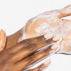 Hands massaging the cleanser into a light emulsion