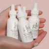 Hand holding three Bio-Renew EGF Drops bottles