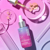 Super-B oil bottle with dropper and petri dishes on pink background