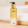 ISDIN Essential Cleansing Oil bottle on a bathroom counter