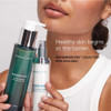 Woman holding two Barrier Pro bottles