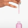 Hand squeezing the dropper of pink Liquid Peelfoliant
