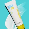 Clearing Defense SPF 30 tube on a teal backdrop with a swipe of lotion