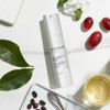 Cream bottle with leaves, berries and coffee beans on marble