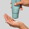 Hand squeezing cleanser from the tube into a palm
