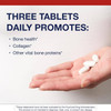 Hand holding three tablets with daily serving text