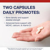 Two capsules in a hand with two capsules daily text