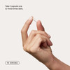 Hand holding a capsule with take one to three times daily text