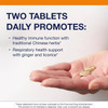 Hand holding Essential Defense tablets, two tablets daily with ginger and licorice graphic