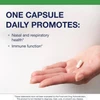 Hand holding a capsule, one capsule daily graphic