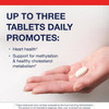 Hand holding a tablet with up to three tablets daily text