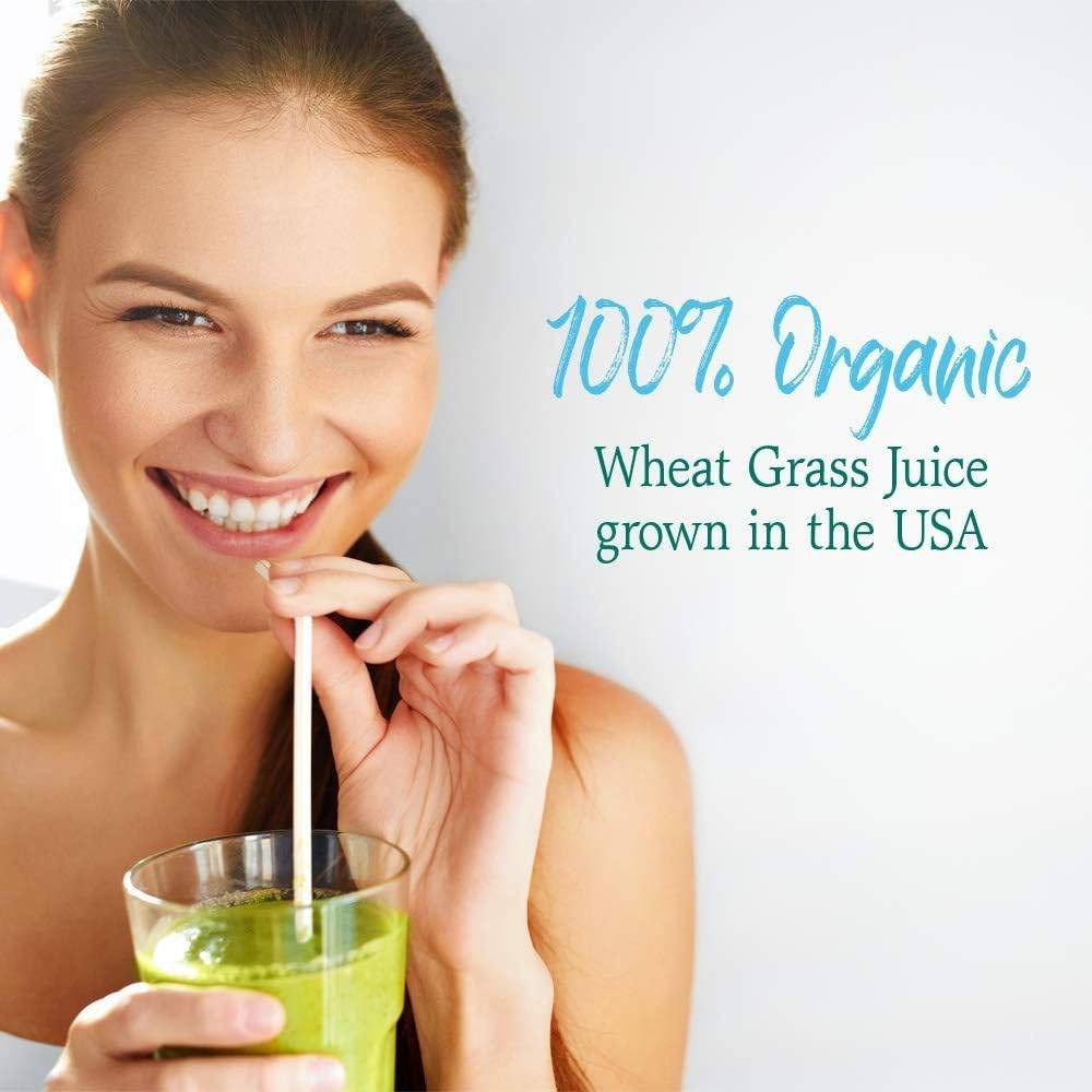 Woman sipping a green drink, 100% organic wheat grass juice grown in the USA