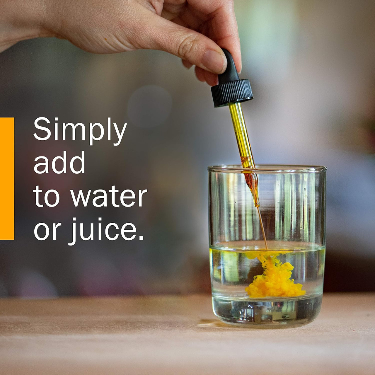 Hand adding drops of extract to a glass of water, simply add to water or juice