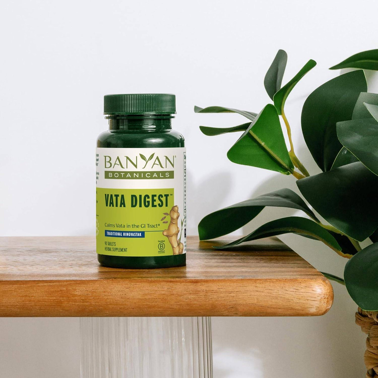 Banyan Botanicals Vata Digest bottle on a wooden table with plants