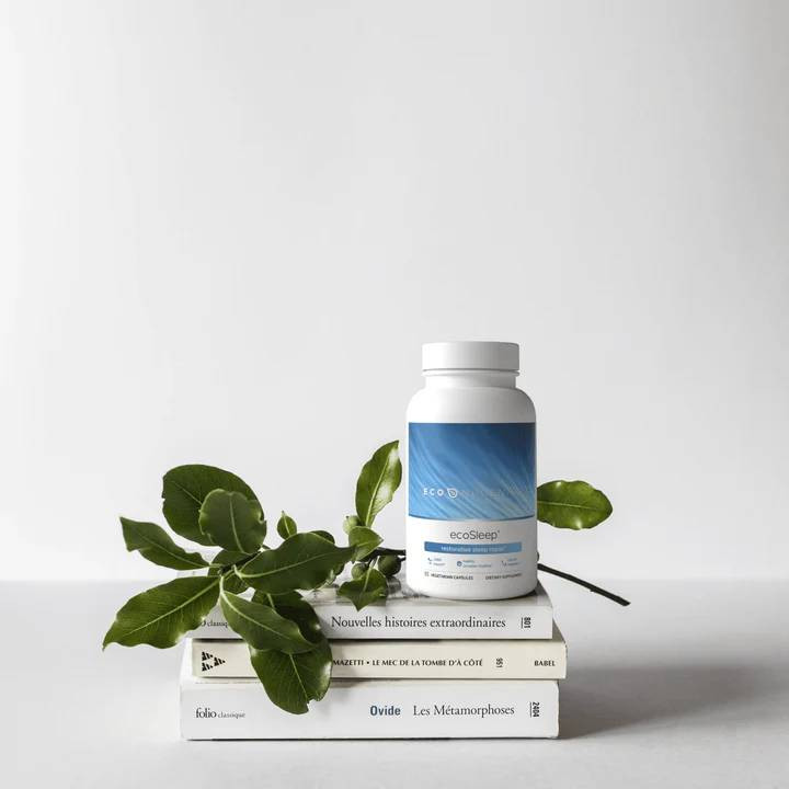 ecoSleep bottle balanced on a stack of books with a leafy stem