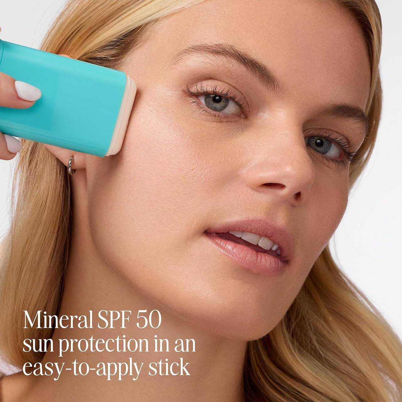 Woman swiping the stick on her cheek, mineral SPF 50 in an easy-to-apply stick