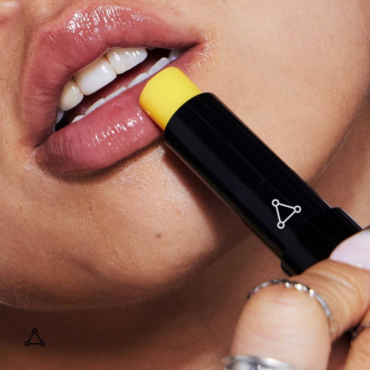 Applying the yellow lip balm to smiling lips
