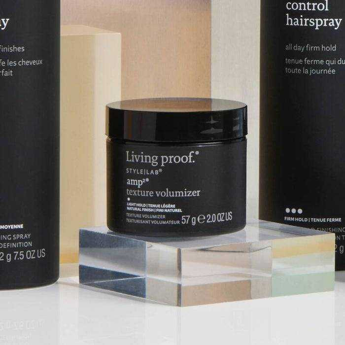 amp2 Texture Volumizer jar beside Control Hairspray on textured surface