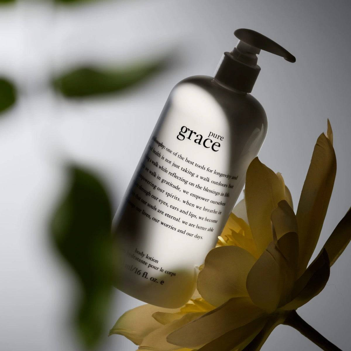 pure grace firming body emulsion bottle among yellow flower petals