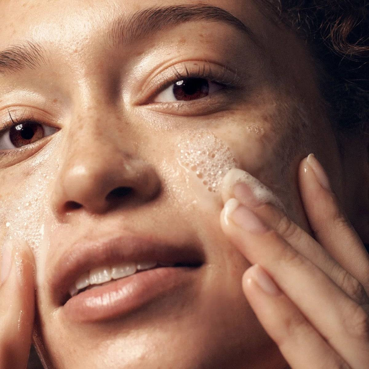 Woman massaging foamy cleanser onto her face