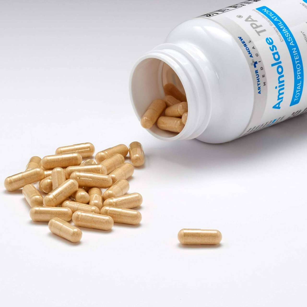 Aminolase TPA bottle with spilled capsules on blue