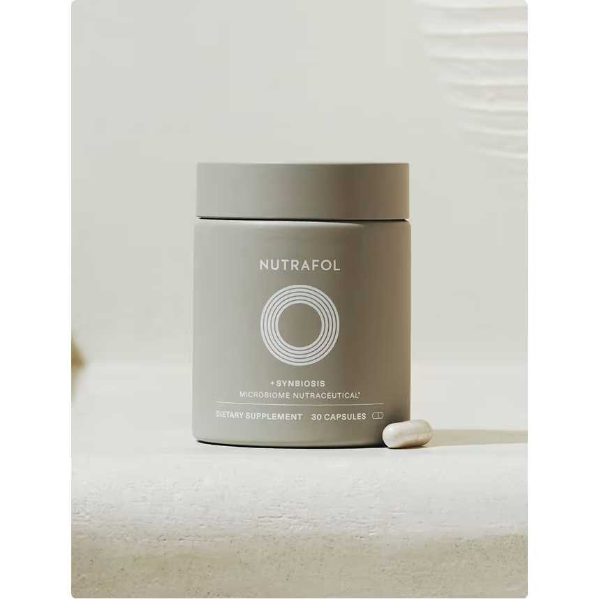 Nutrafol +Synbiosis jar with a capsule on a stone surface