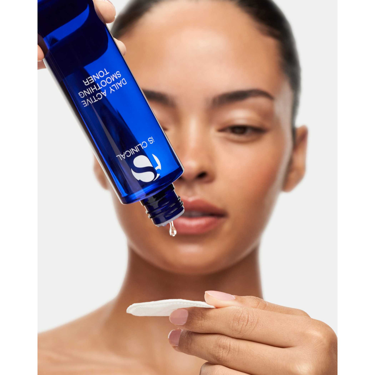 Woman pouring Daily Active Smoothing Toner onto cotton pad