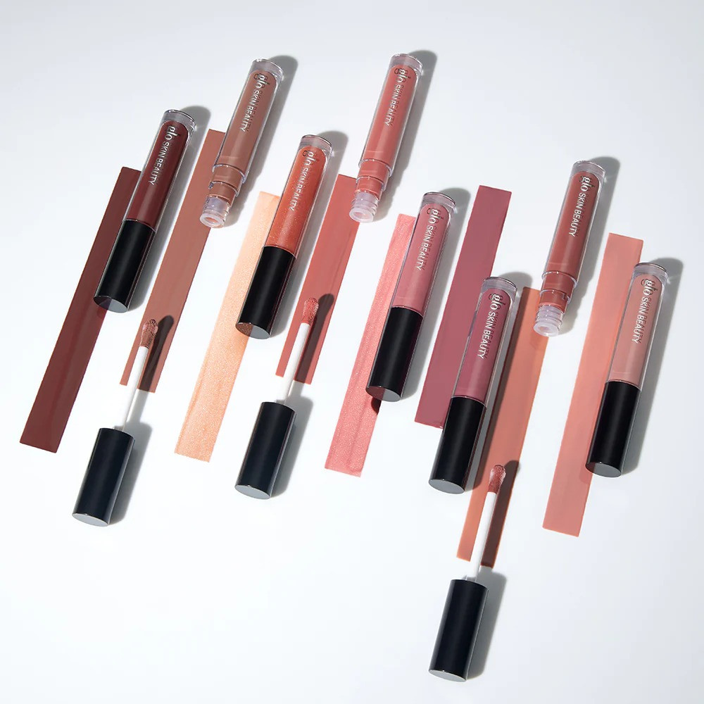 Lip gloss tubes laid diagonally on color blocks