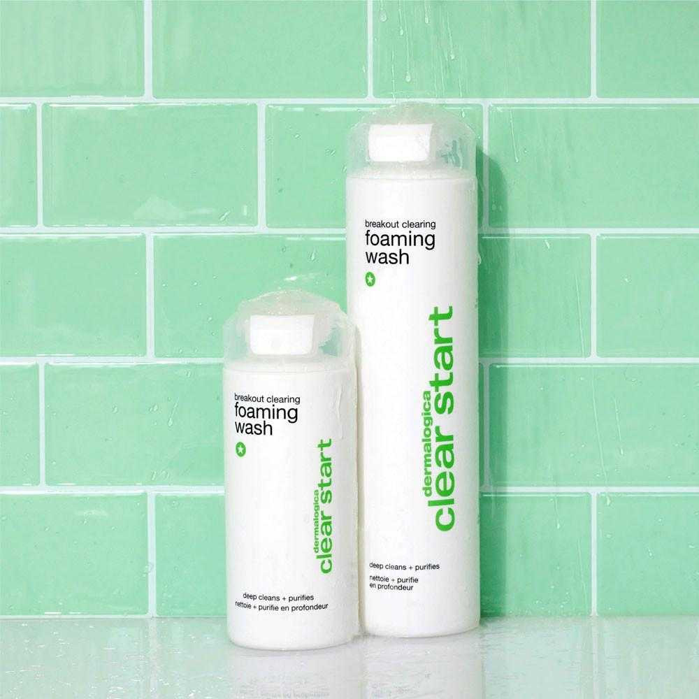 Small and large Clear Start foaming wash bottles on a green tile shelf