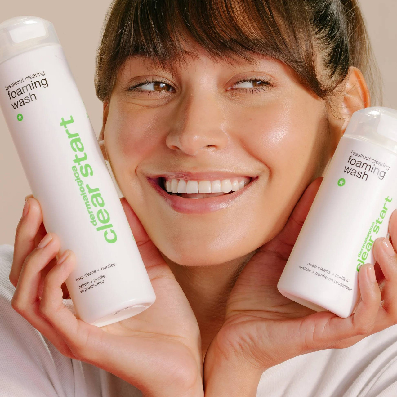 Smiling woman holding two Clear Start foaming wash bottles