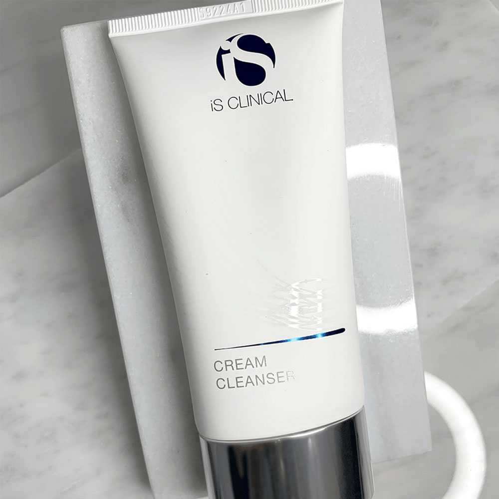 iS Clinical Cream Cleanser tube on a marble surface