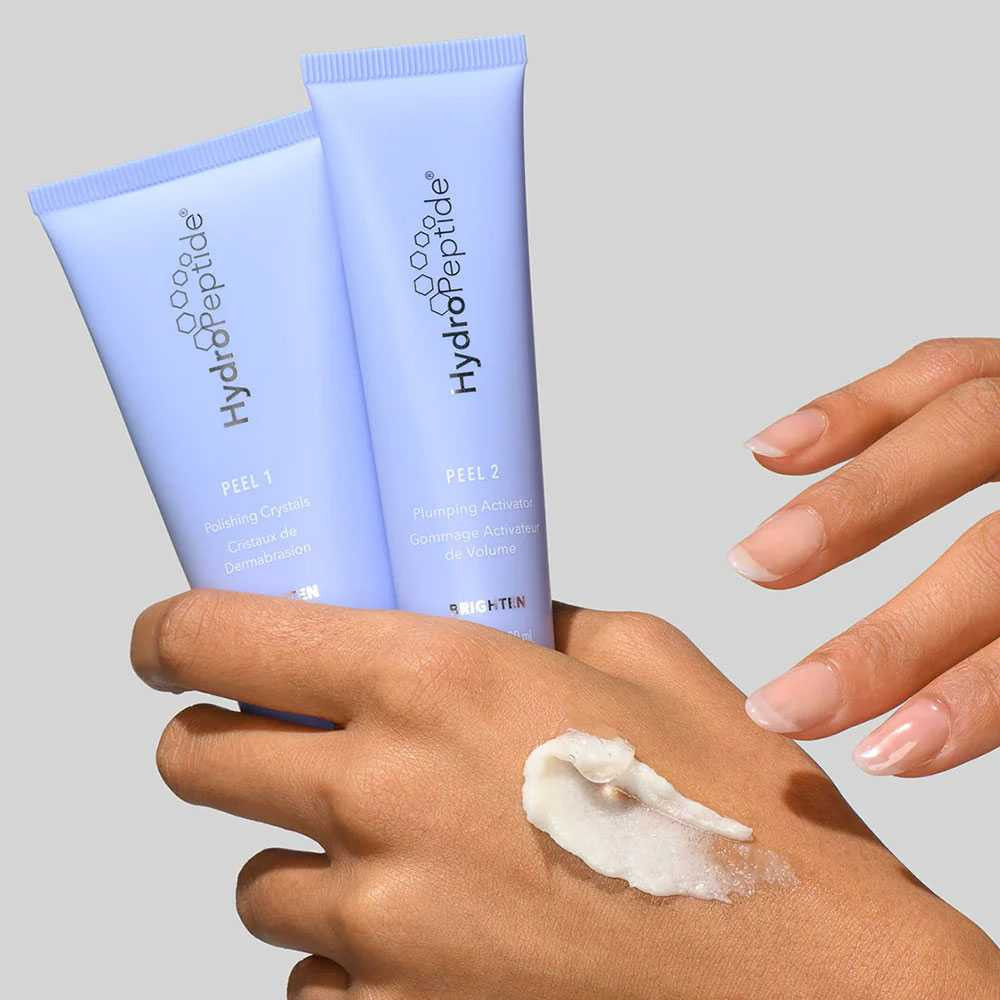 HydroPeptide Polish and Plump Peel tubes with exfoliating cream on the back of a hand
